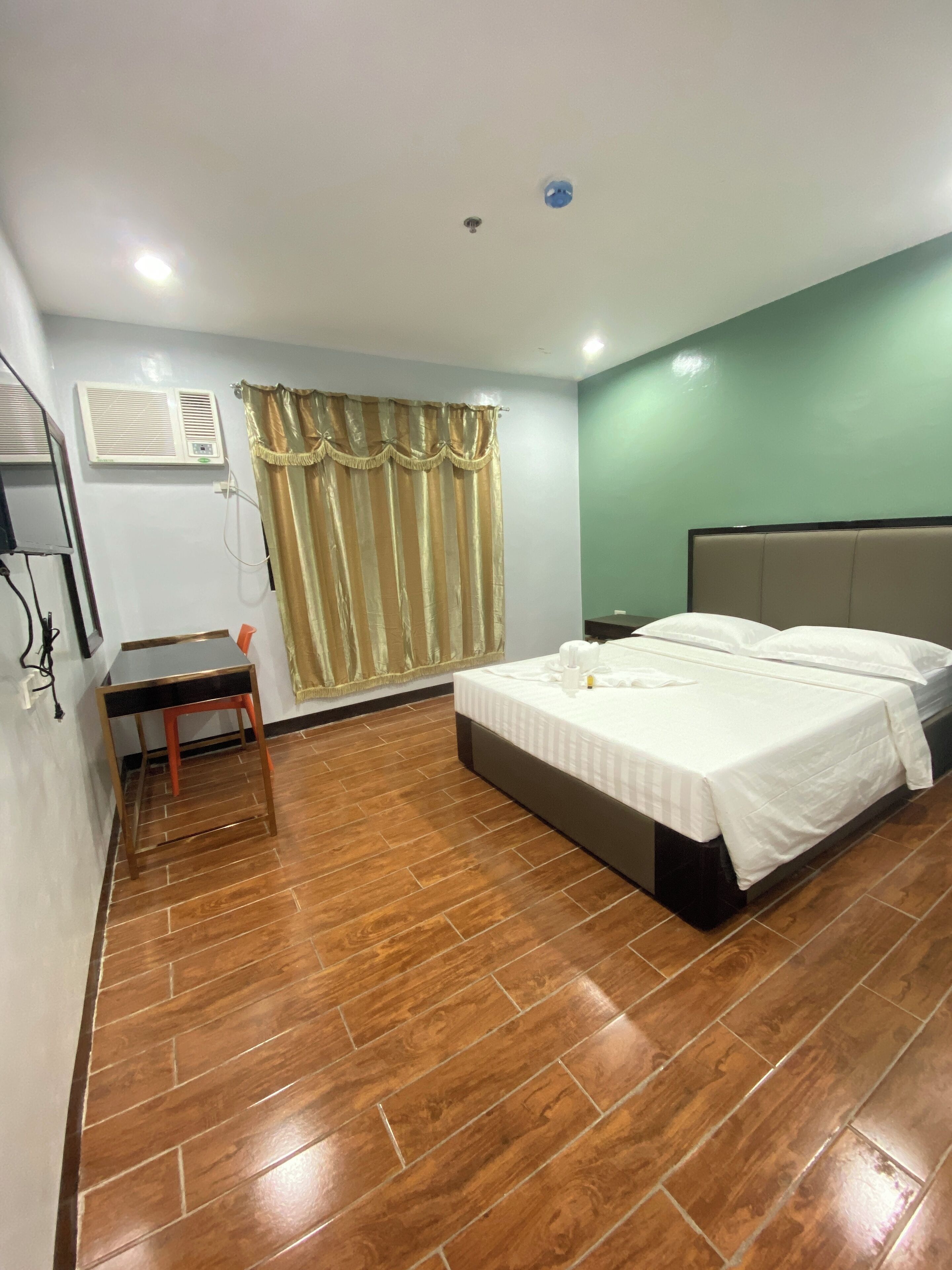 Un dormitorio con una cama, un escritorio y una silla.