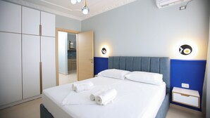 Una camera d'albergo con un letto grande, due comodini, un armadio e uno specchio.
