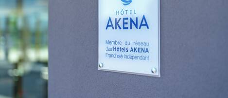 A sign for Hotel Akena, indicating it is part of the Akena Hotel chain and an independent franchise.
