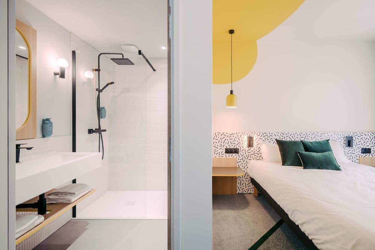 Une salle de bain moderne avec une douche, un lavabo et un miroir.