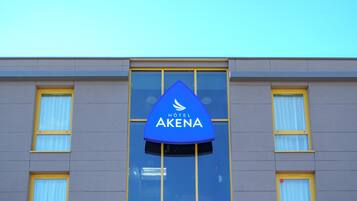 Et hotelskilt med navnet "HOTEL AKENA" på en bygningsfacade.