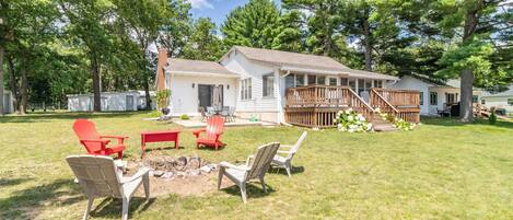 A house with a deck, a fire pit, and outdoor seating.