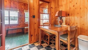 Un interior de madera con una mesa, sillas y una lámpara de madera.