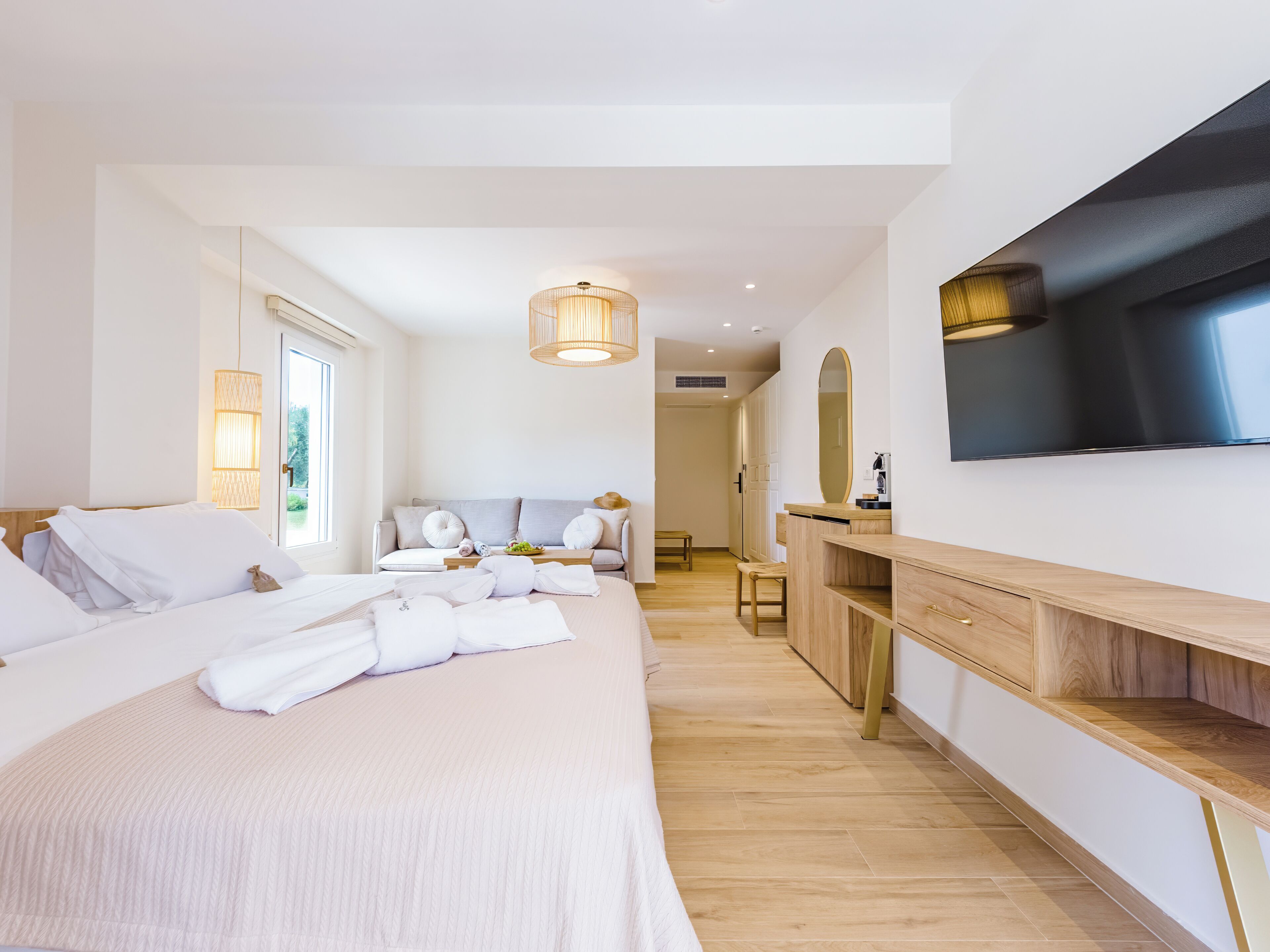 Une chambre d’hôtel moderne dotée d’un grand lit, d’un bureau, d’une télévision et offrant une vue sur l’extérieur.