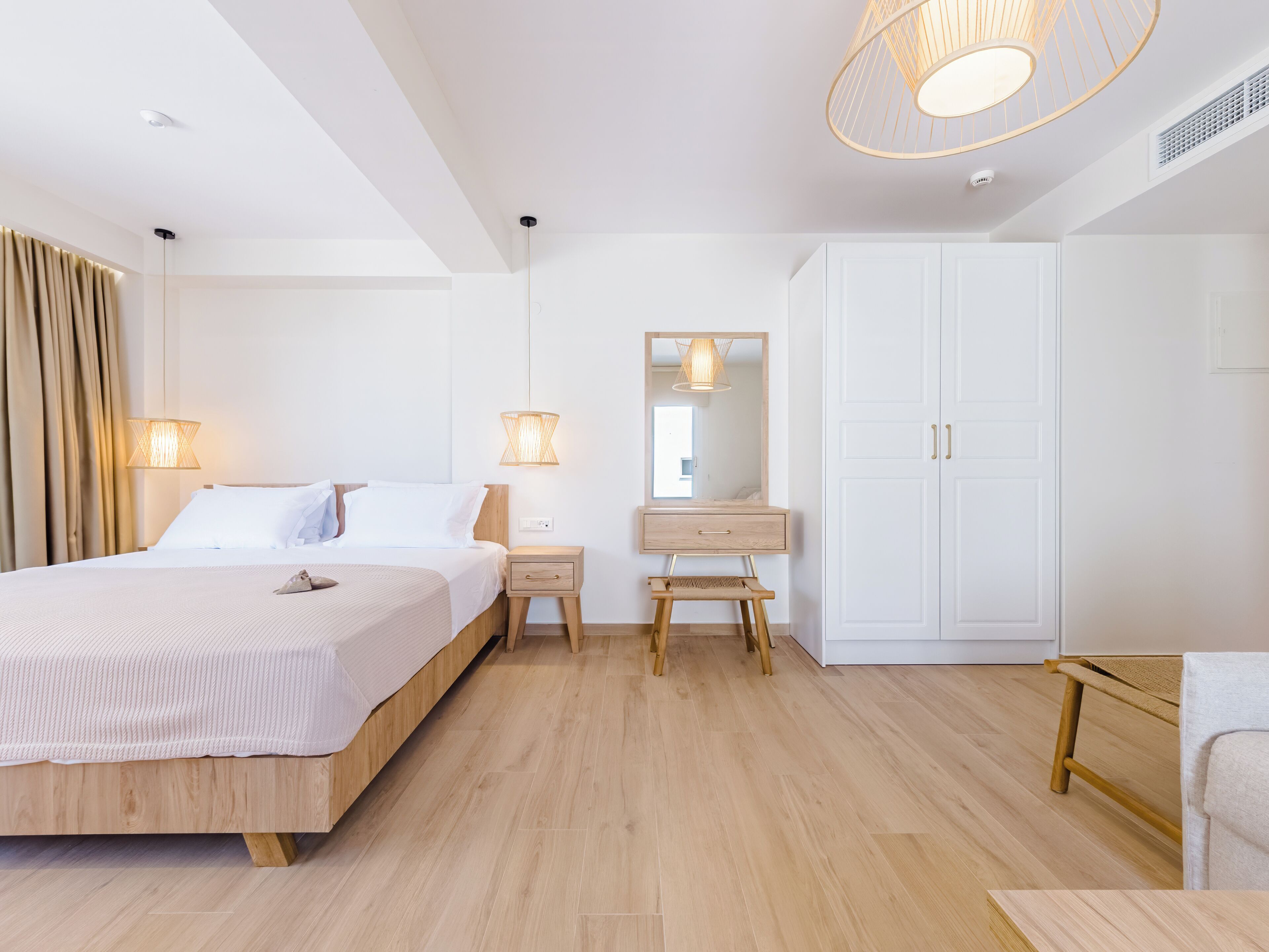A modern bedroom with a wooden bed, bedside tables, a mirror, and a wardrobe.