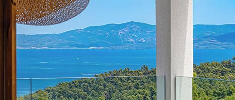A balcony with a view of a mountainous landscape and a body of water.