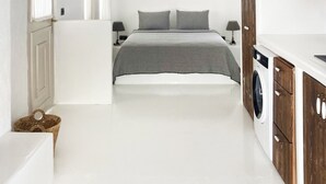 Ein Schlafzimmer mit einem Bett, einer Waschmaschine und einer Holzbalkendecke.