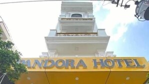 Fachada del Hotel Pandora, con una entrada despejada y una motocicleta estacionada afuera.