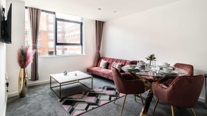 Un salon moderne avec un canapé, une table à manger en verre et une table basse.