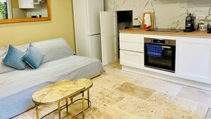 Eine kleine Küche mit Einbauofen, Kühlschrank und einer Holzarbeitsplatte.