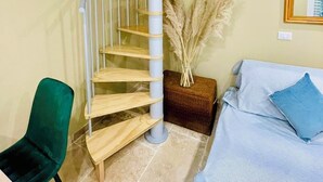 Eine Wendeltreppe mit Holzboden und Metallgeländer, die zu einer oberen Etage führt.