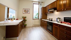 Eine Küche mit Holzausstattung, einer weißen Arbeitsplatte und einem Blick ins Freie durch ein Fenster.