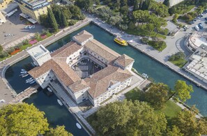 Una vista aerea di un edificio storico con un cortile centrale, adiacente a un canale.