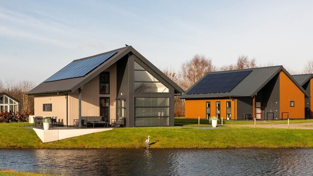 Una casa moderna con tetto spiovente, ampie finestre e pannello solare.
