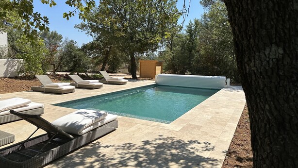 Ein Schwimmbecken mit Liegestühlen und einer Holzterrasse.