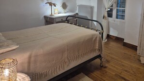 Une chambre à coucher avec un lit, une lampe de chevet et un bureau avec une chaise.