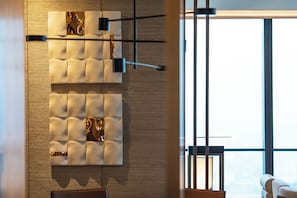 A modern interior with a wooden wall, a cushioned panel, and a large window.
