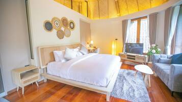 Una habitación de hotel moderna con una cama grande, un escritorio, un televisor y un sofá.