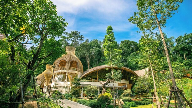 A garden with a pathway leading to a structure with a dome and a covered area. - T-Story Maekampong (Mae On)