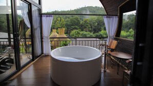 A modern bathroom with a large bathtub, a wooden bench, and a view of lush greenery. - T-Story Maekampong (Mae On)