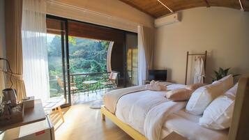 Un dormitorio con una cama grande, televisión y balcón con vistas al exterior.