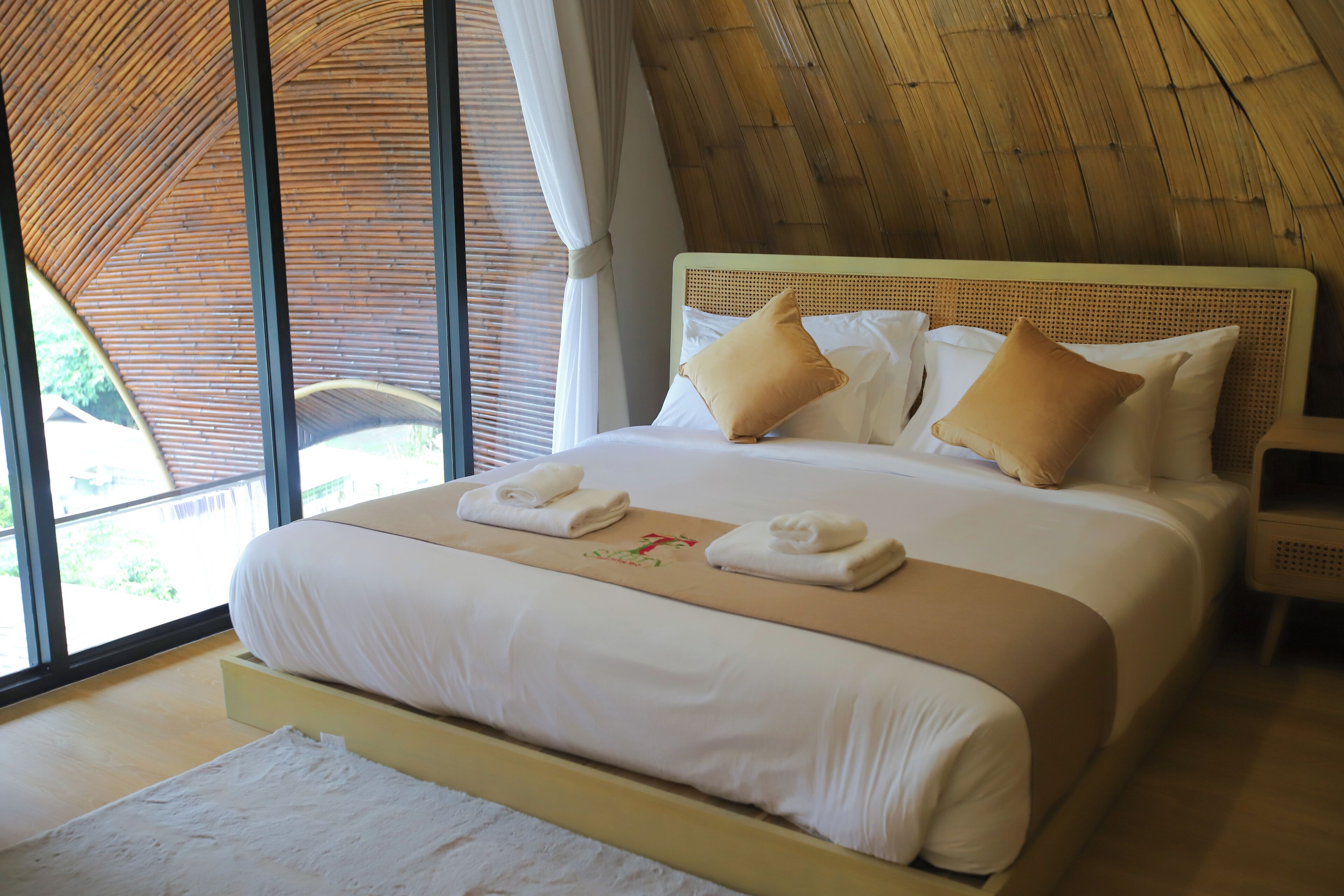 Ein Bett mit weißen Laken, zwei Kissen und zwei Handtüchern darauf.
