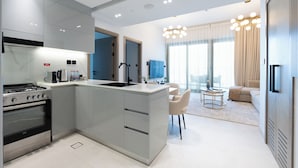 A modern kitchen with a central island, built-in oven, and a dining area with a round table and chairs.