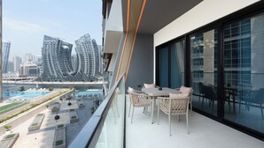 A balcony with a view of a cityscape, including modern buildings and a waterfront.