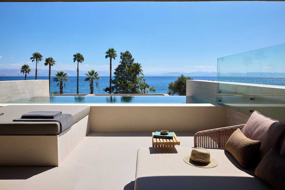 Un balcon avec vue sur la mer, les palmiers et les montagnes.