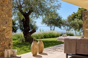 An outdoor seating area with a view of the sea, stone walls, and a tree. - Avali, Mar-Bella Collection (Corfu)