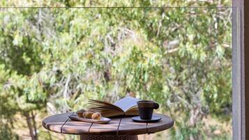A wicker table with a book, a cup, and some nuts.