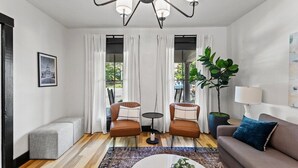 A modern living room with a chandelier, two leather armchairs, a sofa, a coffee table, and a potted plant. - This house is a 2 bedroom(s), 2 bathrooms, located in Frankfort, KY. (Frankfort)