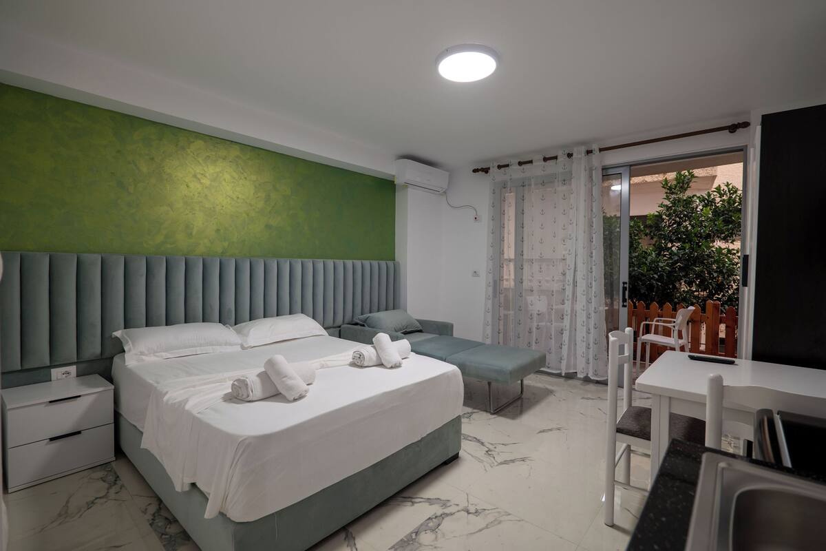 Une chambre d’hôtel moderne équipée d’un lit, d’une table de chevet et d’un petit coin salon.