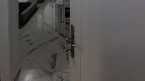 A hotel room with a bed, a desk, and a bathroom visible through an open door. - Star&Sea Saranda (Sarandë)
