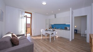 A modern apartment with a living room, dining area, and kitchen. - Appartamento Blu in Riva del Garda (Riva del Garda)