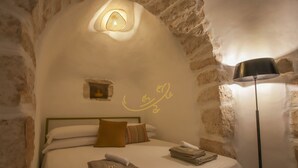 Une pièce confortable avec un lit, une lampe et un mur au décor original.