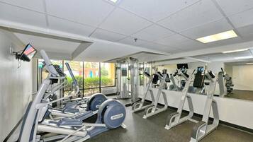 A gym with treadmills, elliptical machines, and weight equipment.