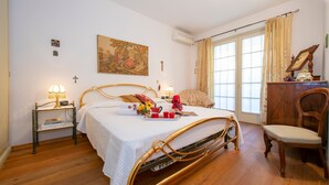 Une chambre bien rangée, avec un lit, des tables de chevet, une chaise et une fenêtre avec des rideaux.