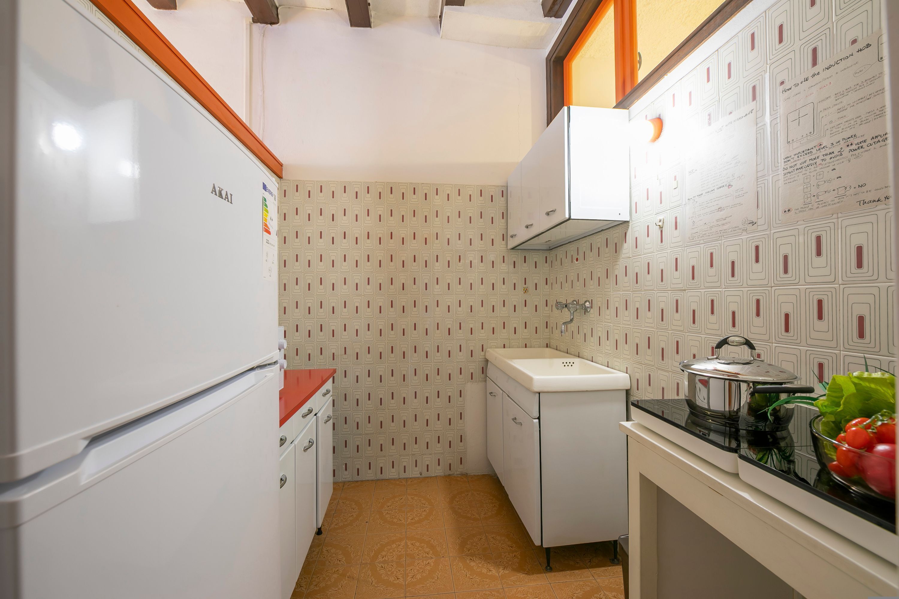 A compact kitchen with a refrigerator, sink, and countertop.