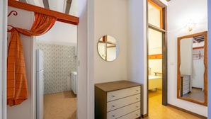 A hotel room with a wardrobe, a mirror, and a bathroom visible through an open door. - Sergio Il Gufo - Orange in Historic Cente (Toscolano Maderno)