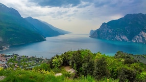 A coastal town with a view of a calm sea and mountains. - Casa Azzurra 150m From Lake (Riva del Garda)