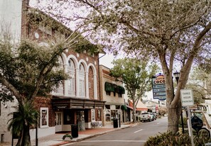 A street view with a historic building featuring arched windows and a sign for 'City of Cocoa'. - Island Oasis with Heated Pool, Putt Putt Course, Tiki Bar, and Beach Gear! (Merritt Island)