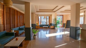 Un vestíbulo amplio con zona de estar, un gran ventanal con vistas a la ciudad y un diseño de interiores moderno.