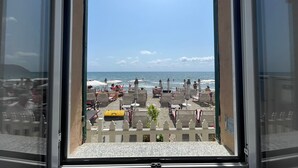 A view from a window overlooking a beach with umbrellas and chairs. - La Casa Sulla Spiaggia (Alassio)