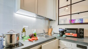 A modern kitchen with a built-in oven, a microwave, and a washing machine. - La Casa Sulla Spiaggia (Alassio)