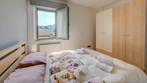 Une chambre à coucher avec un lit, une fenêtre, un radiateur et des armoires en bois.