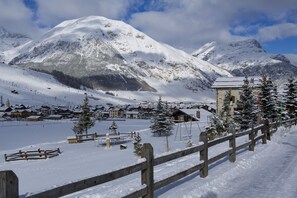A snow-covered mountain village with wooden buildings and a wooden fence. - Ermellino Ski in - Ski out Mt 150 (Livigno)