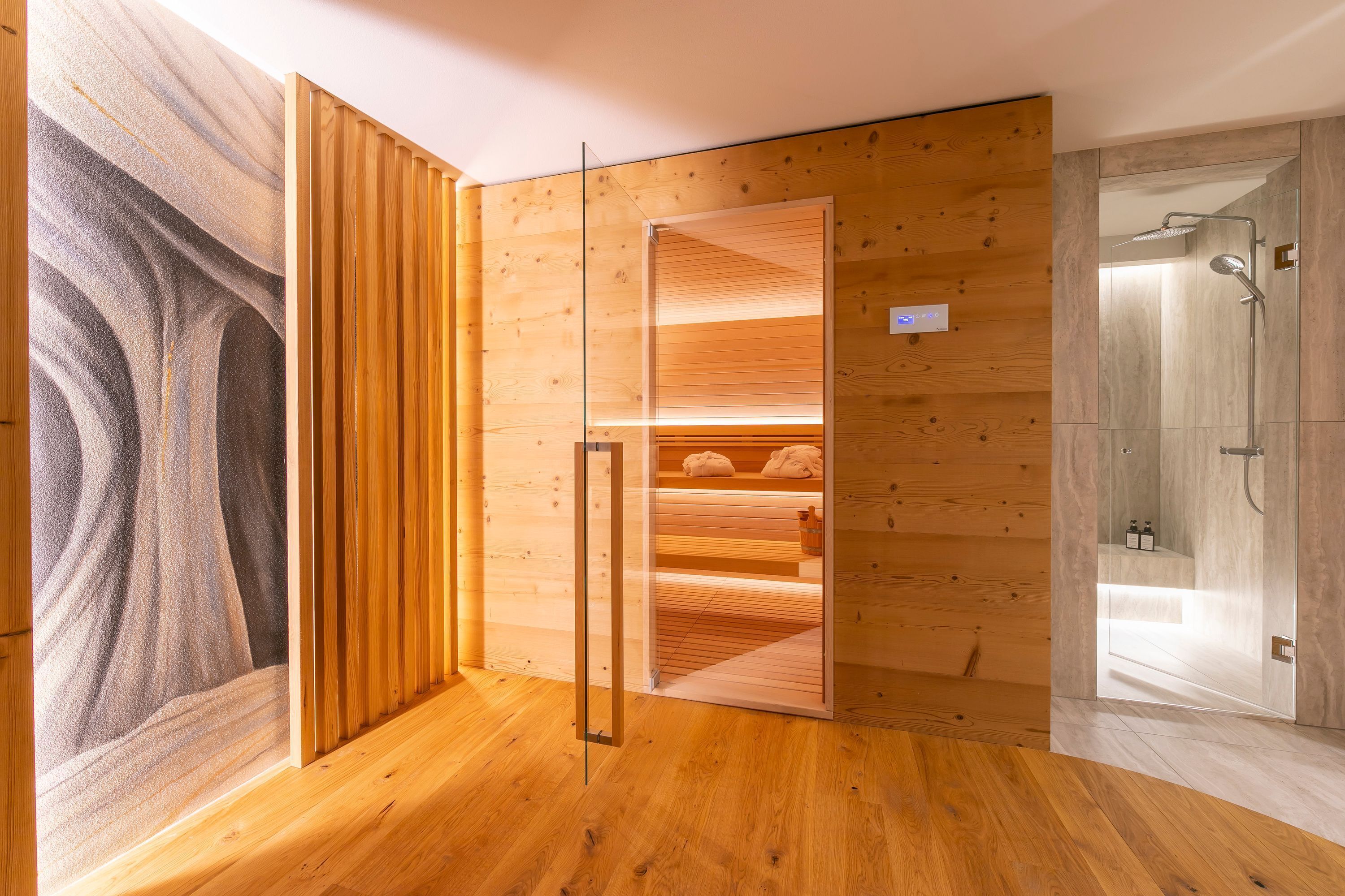 Ein modernes Badezimmer mit Holzverkleidung, einer Duschkabine aus Glas und einem sichtbaren Handtuchhalter.