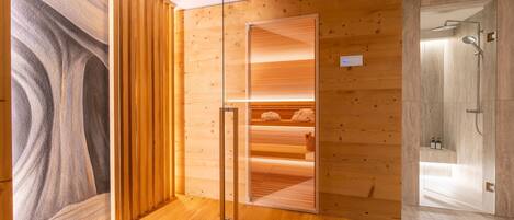 Ein modernes Badezimmer mit Holzverkleidung, einer Duschkabine aus Glas und einem sichtbaren Handtuchhalter.
