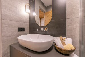 A modern bathroom with a large oval sink, a wooden bowl with bath products, and a mirror with a gold frame. - Menina in Livigno With 1 Bathrooms (Livigno)
